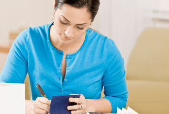 Woman writing in a checkbook