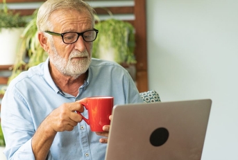 Boomer aged man working on a laptop