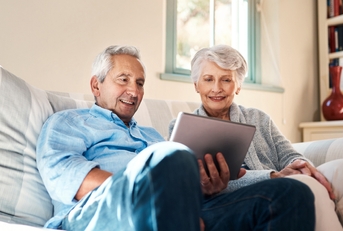 happy senior couple watching on tablet together