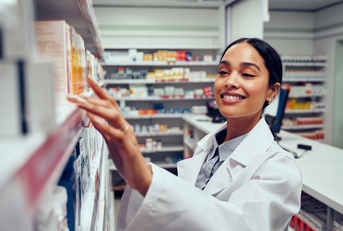 Pharmacist picking medication from shelf