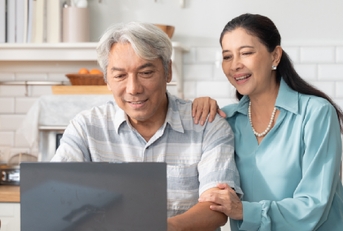 senior asian couple collaborate on a laptop
