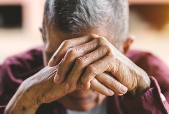 senior man covering his face with his hands