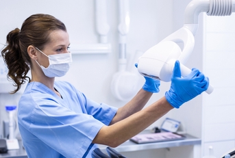 dental assistant adjusting light 
