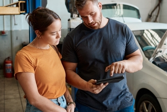 Person talking with a mechanic about the problems with their car