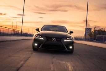 black lexus is driving in city at sunset