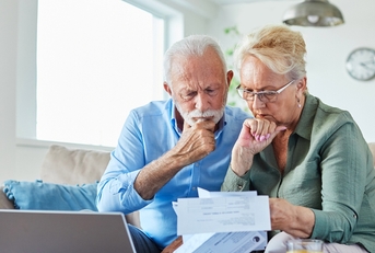 Worried older couple looking at bills