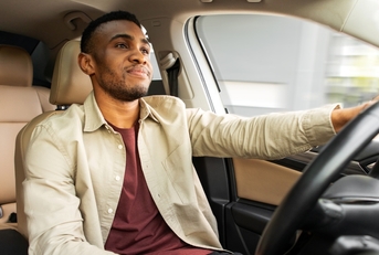 Man driving car with tan leather interior