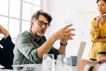 Mature man speaking in meeting