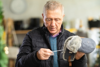 Older man looking at hat price tag