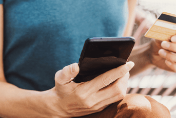 person holding phone and credit card