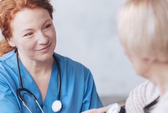 medical worker taking woman's blood pressure
