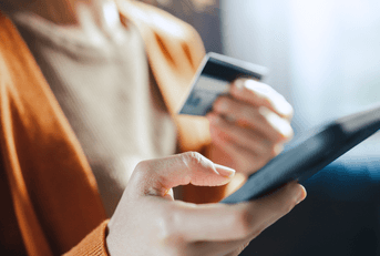 Woman's hands with phone and credit card