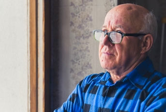 Senior man looking out the window