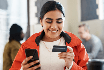 Woman using credit card on phone