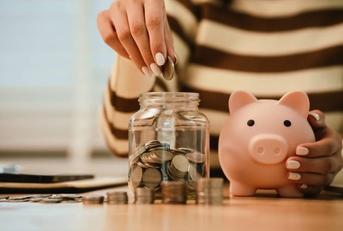 A woman holds a piggy bank