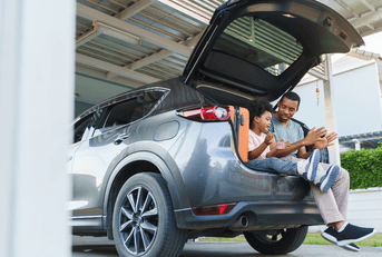Father and son sitting in car on vacation