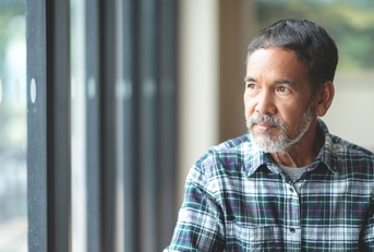 Mature man looking out window