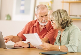 Concerned retired couple on laptop
