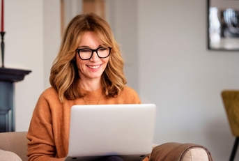 Woman sitting in living room on laptop
