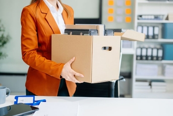 Business woman holding box with desk belongings