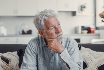 Contemplative older man on couch