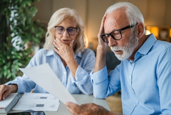 Older couple looking shocked when doing paperwork