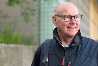 Smiling man in his 60s walking in the city