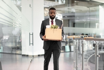 Fired male employee with box of belongings