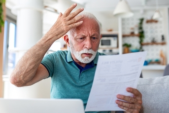 Senior shocked looking at papers