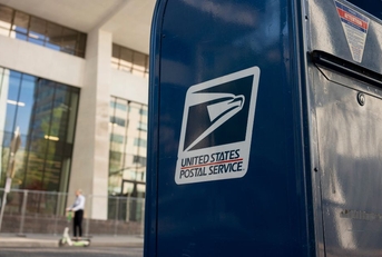 Closeup of a USPS mailbox in a downtown area