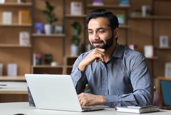 Smiling businessman working on laptop