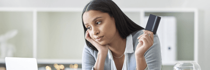 Woman holding a credit card looking stressed