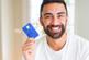 man holding credit card with a happy face
