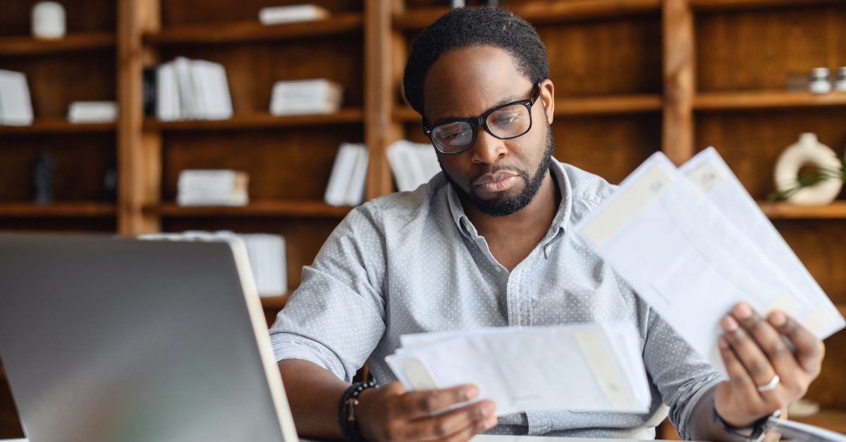 Man looking at papers and computer
