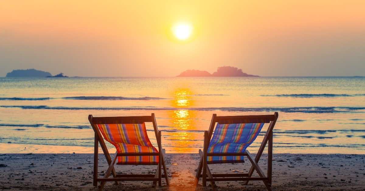 Chairs next to water at sunset