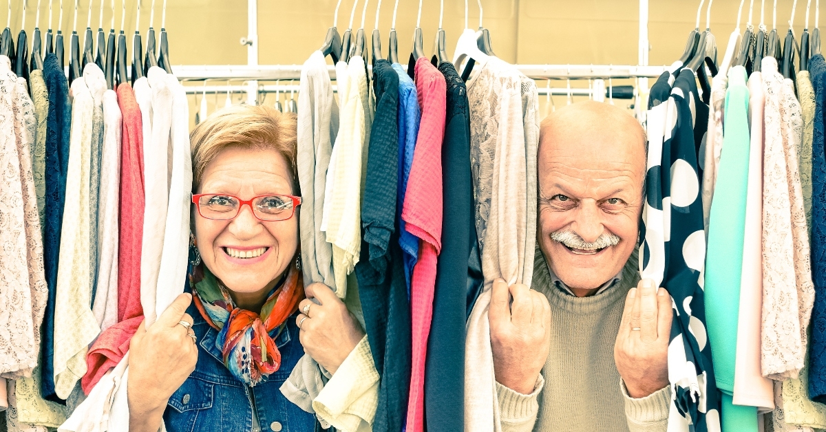 Couple peeking through clothing rack