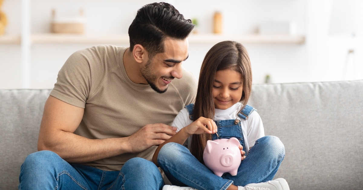 Dad teaching daughter how to save money