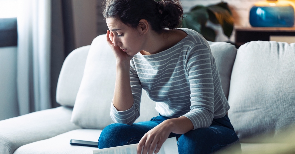 Woman sitting on couch looking stressed