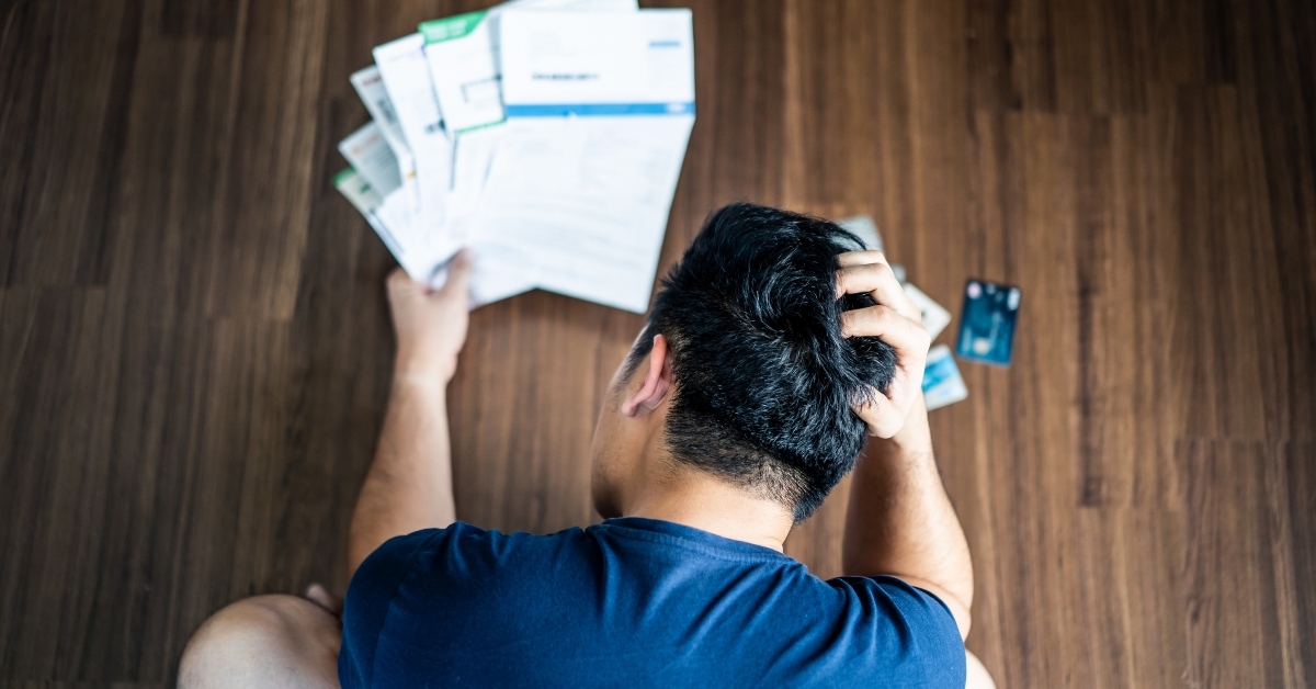 Stressed man holding bills