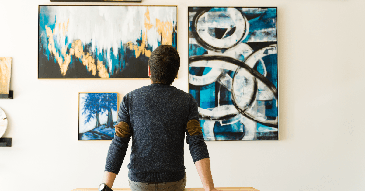 Man looking at paintings