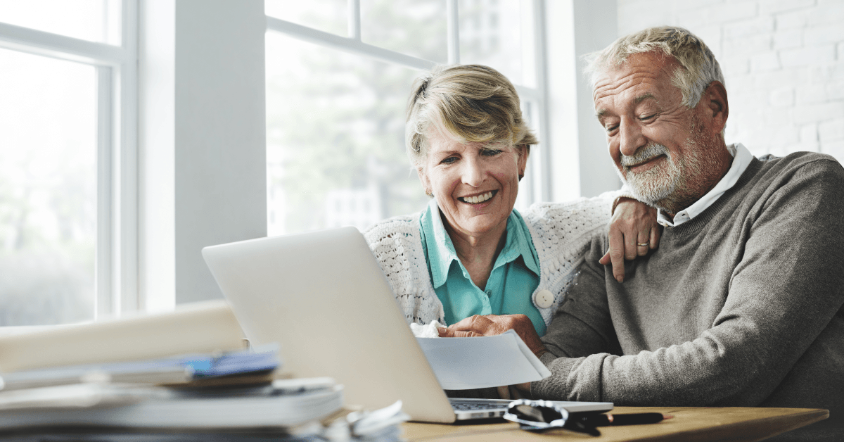 Happy senior couple looking at computer