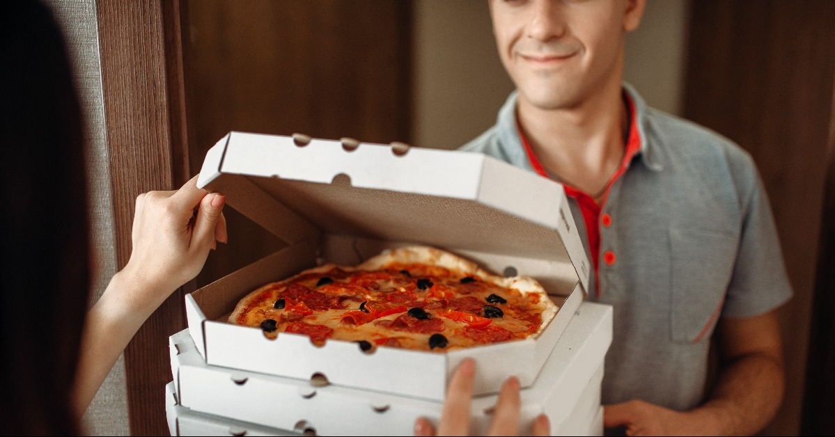 delivery man shows pizza to customer at the door 
