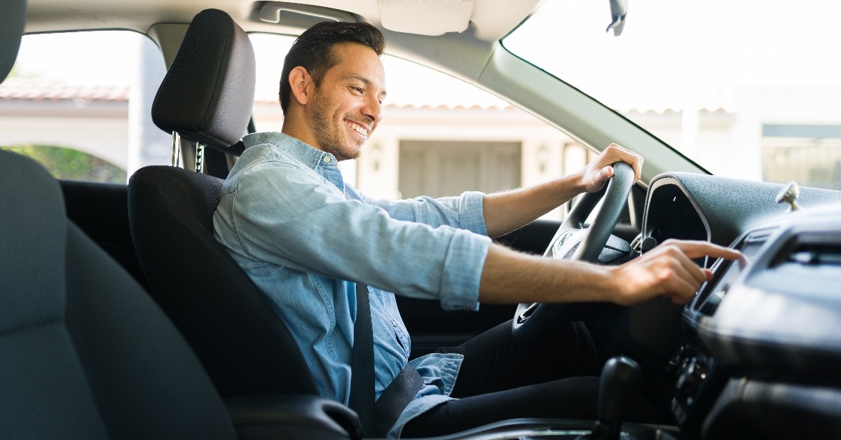 attractive male driver using the GPS navigation map on the car 