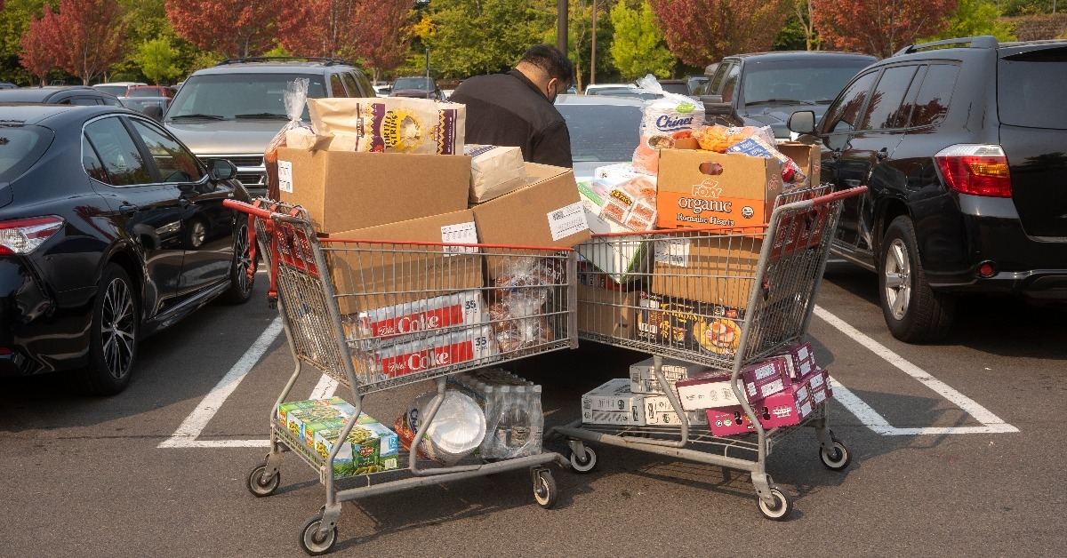 a  masked customer loads his car after shopping in Costco