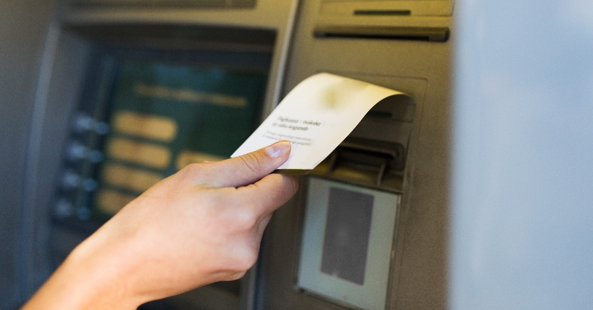 close up of hand taking receipt from atm machine