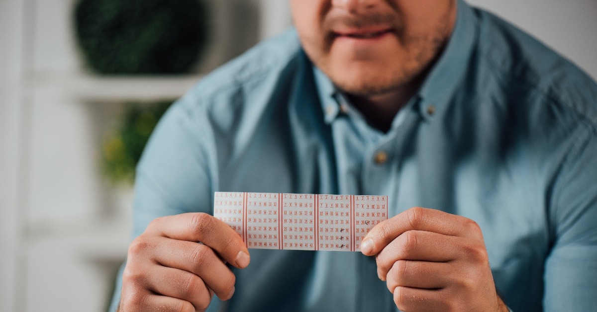 cropped view of worried man holding lottery ticket