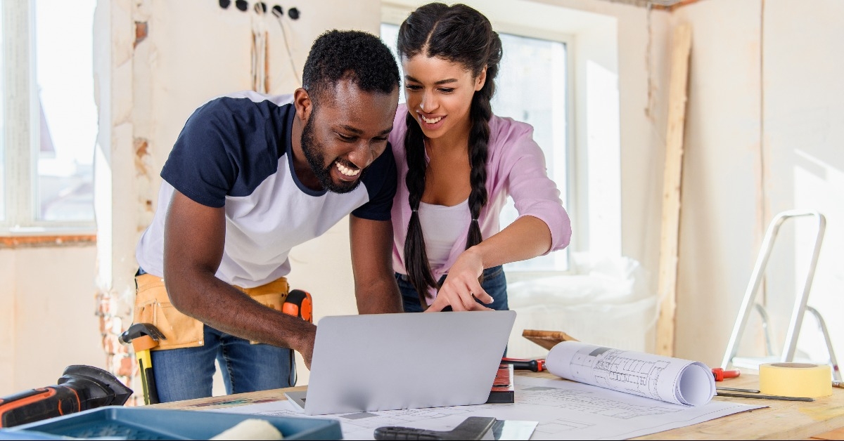 young african american woman pointing at laptop screen to boyfriend