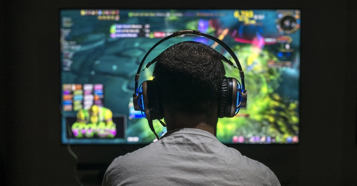 young gamer playing video game wearing headphone
