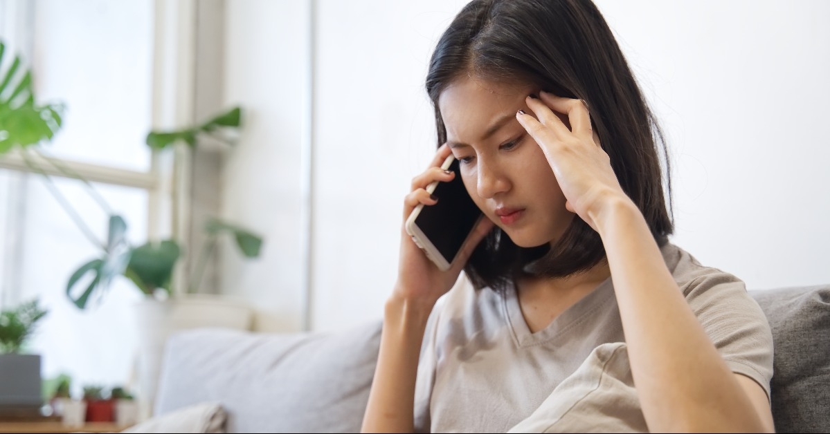 unhappy Asian girl talking on telephone