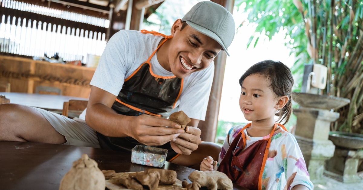 Happy man and child making pottery